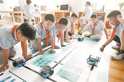 圖為中關(guān)村第三小學(xué)雄安校區(qū)編程社團(tuán)的學(xué)生檢驗(yàn)機(jī)器人的編程效果。新華社記者 李鑫攝