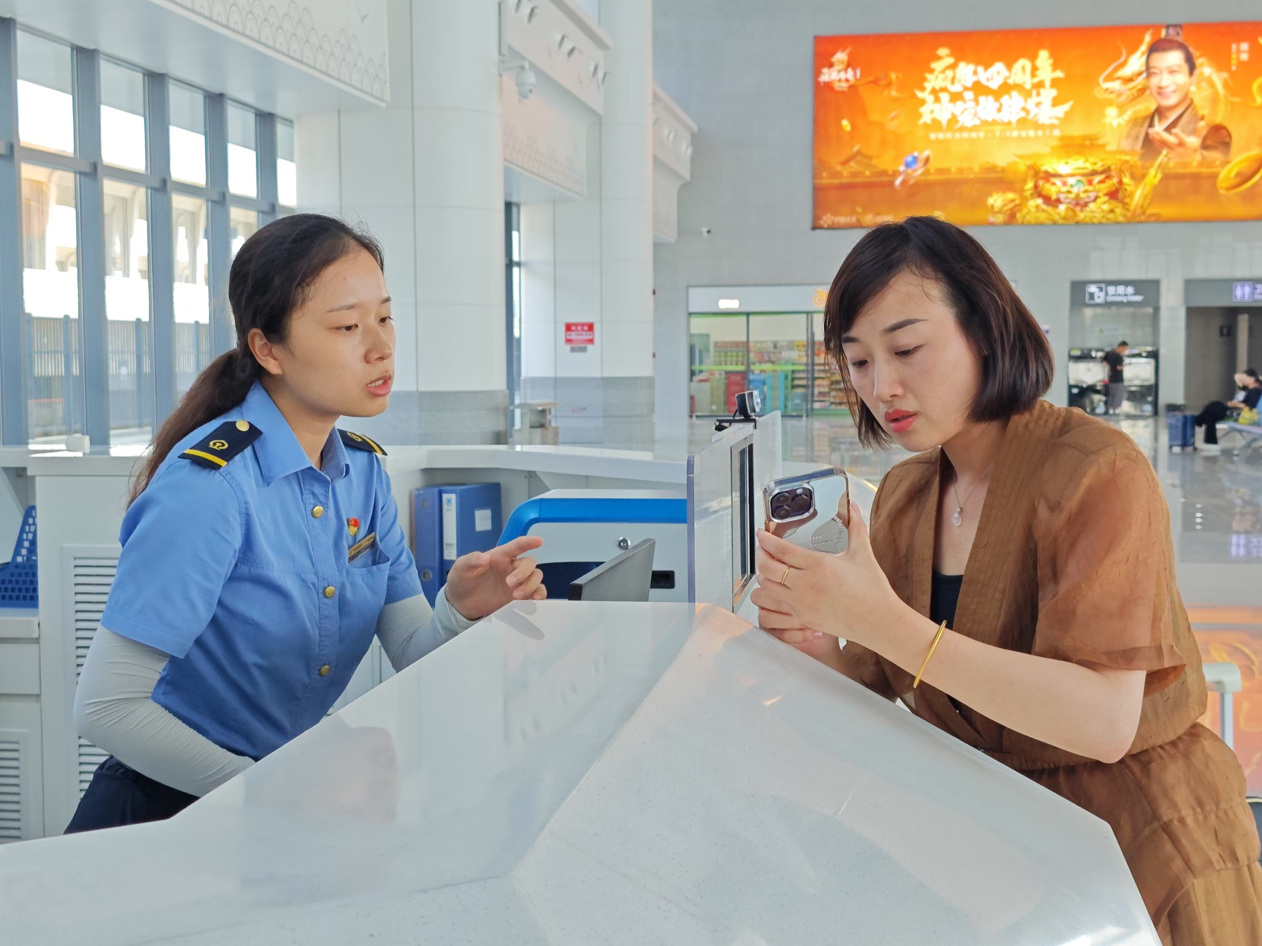 鄱陽站服務(wù)臺(tái)的工作人員在為旅客解答疑惑。余清清 攝.jpg